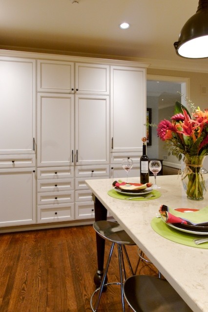 Cette image montre une cuisine bohème avec un placard avec porte à panneau encastré, des portes de placard blanches et un électroménager en acier inoxydable.