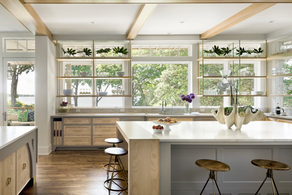 Immagine di un cucina con isola centrale minimal con lavello sottopiano, ante in stile shaker, ante in legno chiaro, parquet scuro, pavimento marrone e top bianco