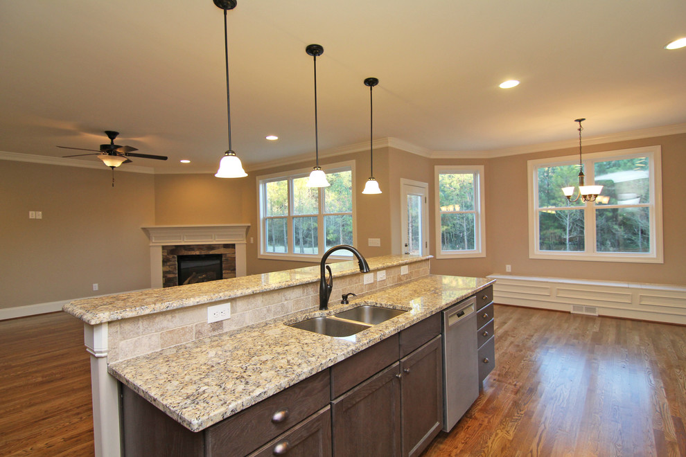 Open concept kitchen - mid-sized traditional u-shaped medium tone wood floor open concept kitchen idea in Raleigh with a double-bowl sink, recessed-panel cabinets, white cabinets, granite countertops, beige backsplash, ceramic backsplash, stainless steel appliances and an island