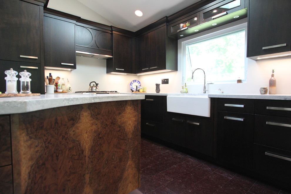 This is an example of a small modern enclosed kitchen in Toronto with a belfast sink, flat-panel cabinets, dark wood cabinets, quartz worktops, stainless steel appliances, cork flooring and an island.