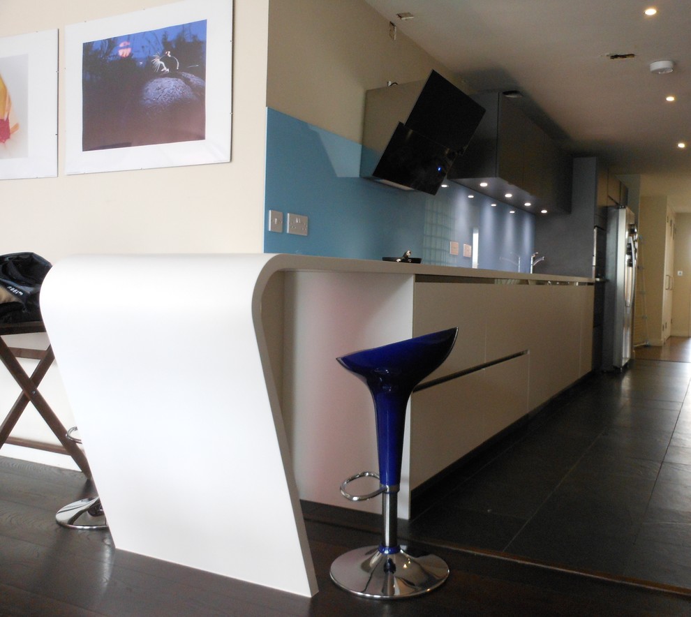 Offene, Einzeilige Moderne Küche mit weißen Schränken, Küchenrückwand in Blau und Glasrückwand in London