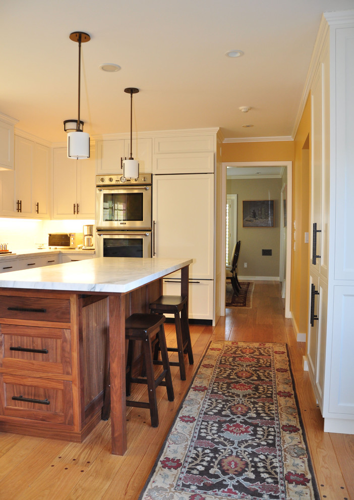 サンフランシスコにあるコンテンポラリースタイルのおしゃれなキッチン (パネルと同色の調理設備、落し込みパネル扉のキャビネット、白いキャビネット、大理石カウンター) の写真