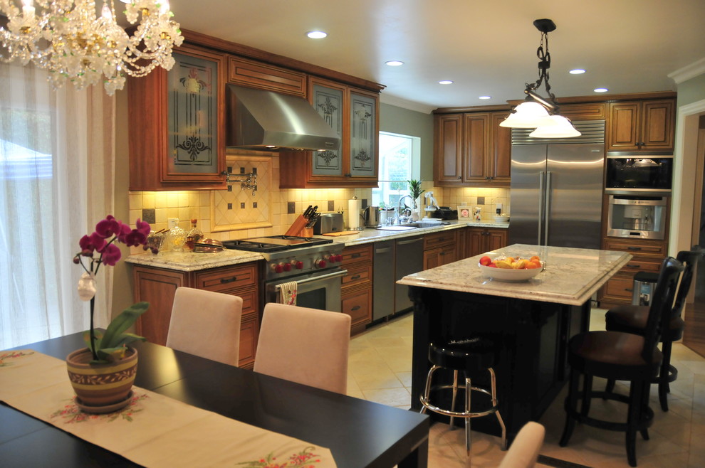 Foto på ett vintage kök, med en undermonterad diskho, luckor med upphöjd panel, bruna skåp, granitbänkskiva, beige stänkskydd, stänkskydd i stenkakel och rostfria vitvaror