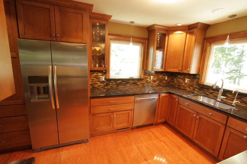 Exempel på ett avskilt modernt l-kök, med en undermonterad diskho, skåp i shakerstil, skåp i mellenmörkt trä, granitbänkskiva, flerfärgad stänkskydd och rostfria vitvaror