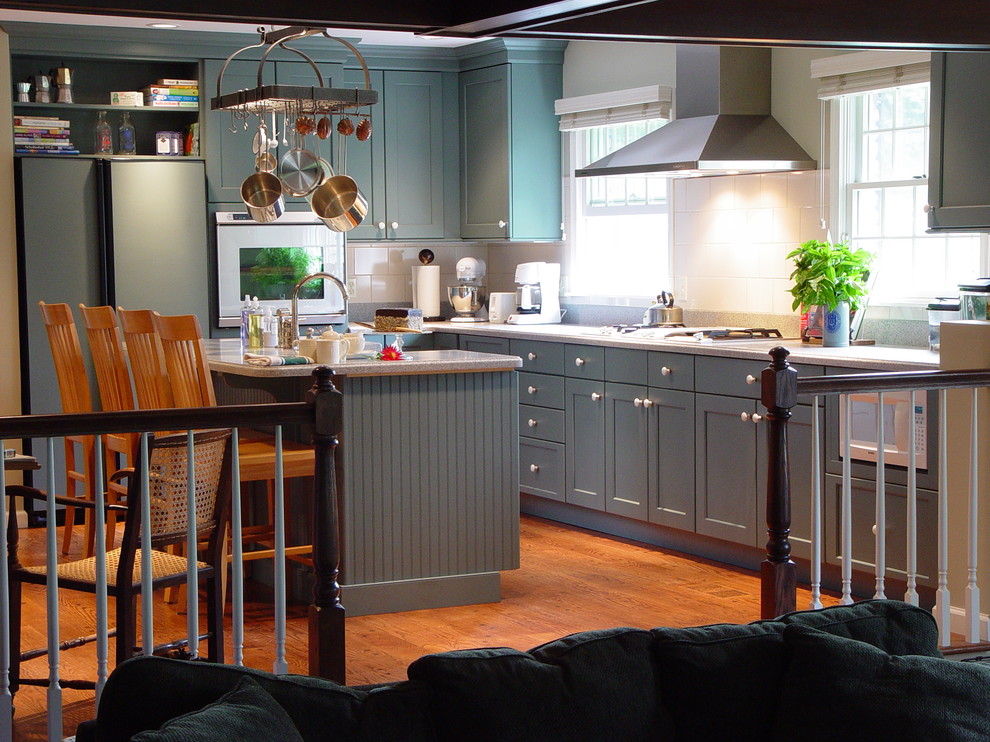 ニューヨークにあるトランジショナルスタイルのおしゃれなキッチン (シェーカースタイル扉のキャビネット、青いキャビネット、白いキッチンパネル、パネルと同色の調理設備、淡色無垢フローリング) の写真