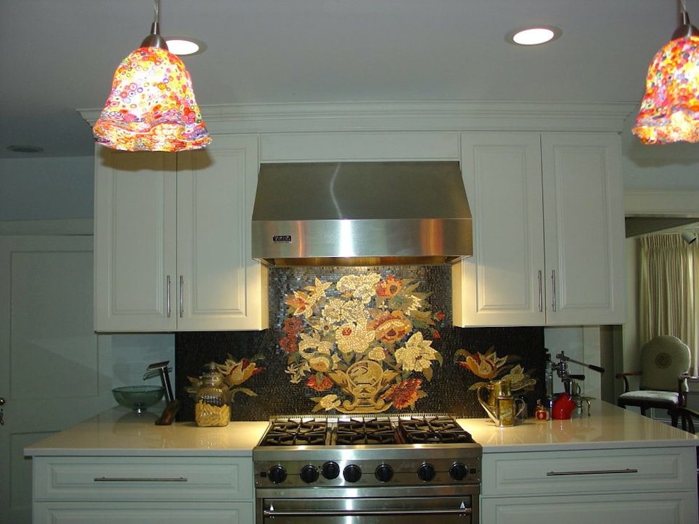 Inredning av ett klassiskt mellanstort kök, med en undermonterad diskho, luckor med upphöjd panel, vita skåp, bänkskiva i kvarts, svart stänkskydd, stänkskydd i mosaik, rostfria vitvaror, skiffergolv och en köksö