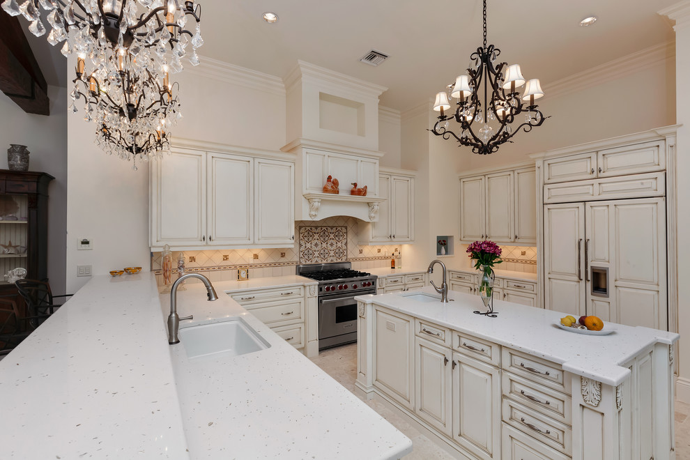 Inspiration for a large timeless u-shaped marble floor kitchen pantry remodel in Tampa with an undermount sink, raised-panel cabinets, white cabinets, marble countertops, white backsplash, ceramic backsplash, stainless steel appliances and an island