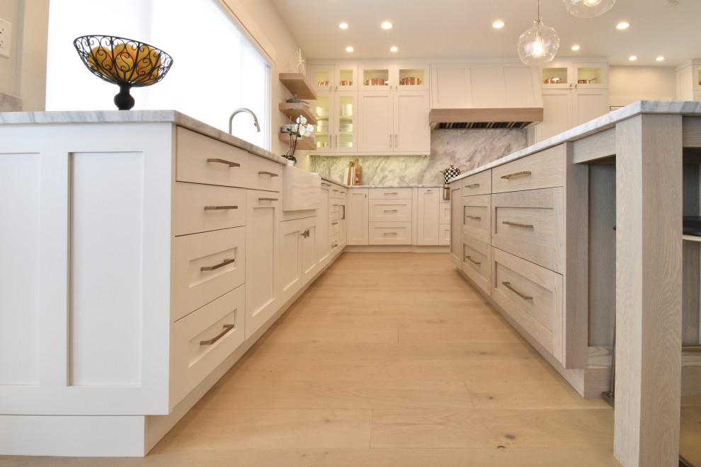 Photo of an expansive nautical kitchen in Other with a belfast sink, shaker cabinets, stainless steel appliances and an island.