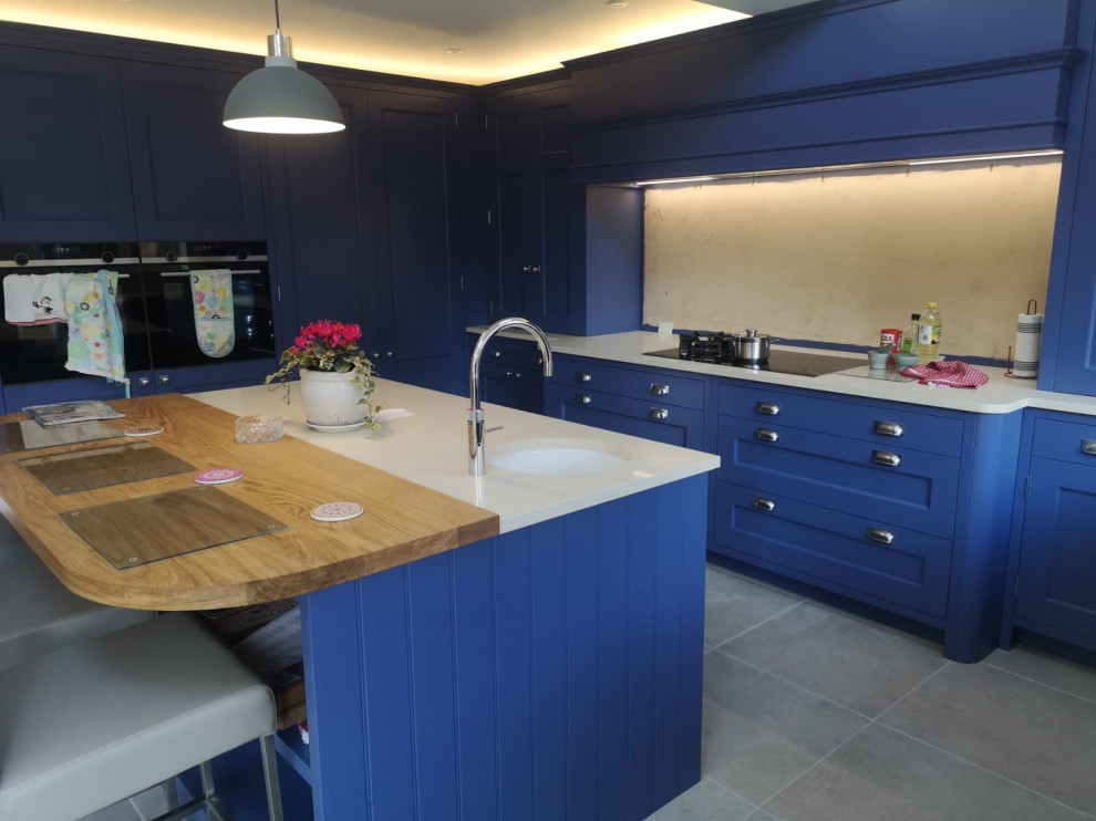 This is an example of a country kitchen in Kent with quartz worktops, an island and beige worktops.