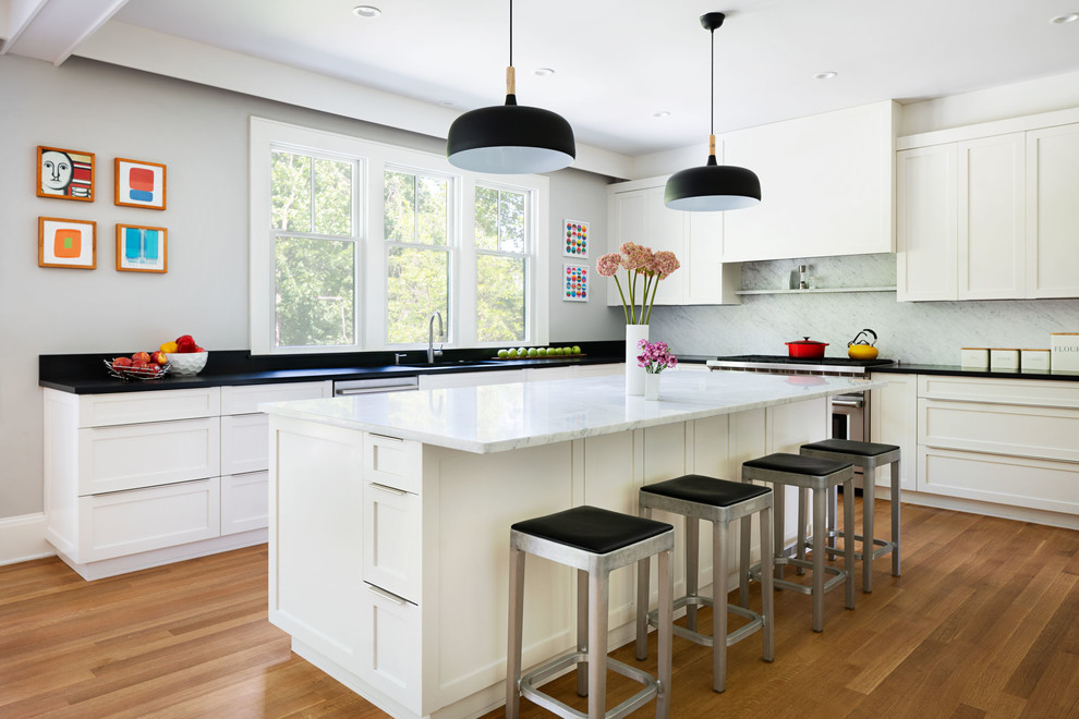 Exempel på ett stort klassiskt grå grått kök, med skåp i shakerstil, vita skåp, rostfria vitvaror, mellanmörkt trägolv, en köksö, en undermonterad diskho, marmorbänkskiva, brunt golv, grått stänkskydd och stänkskydd i marmor