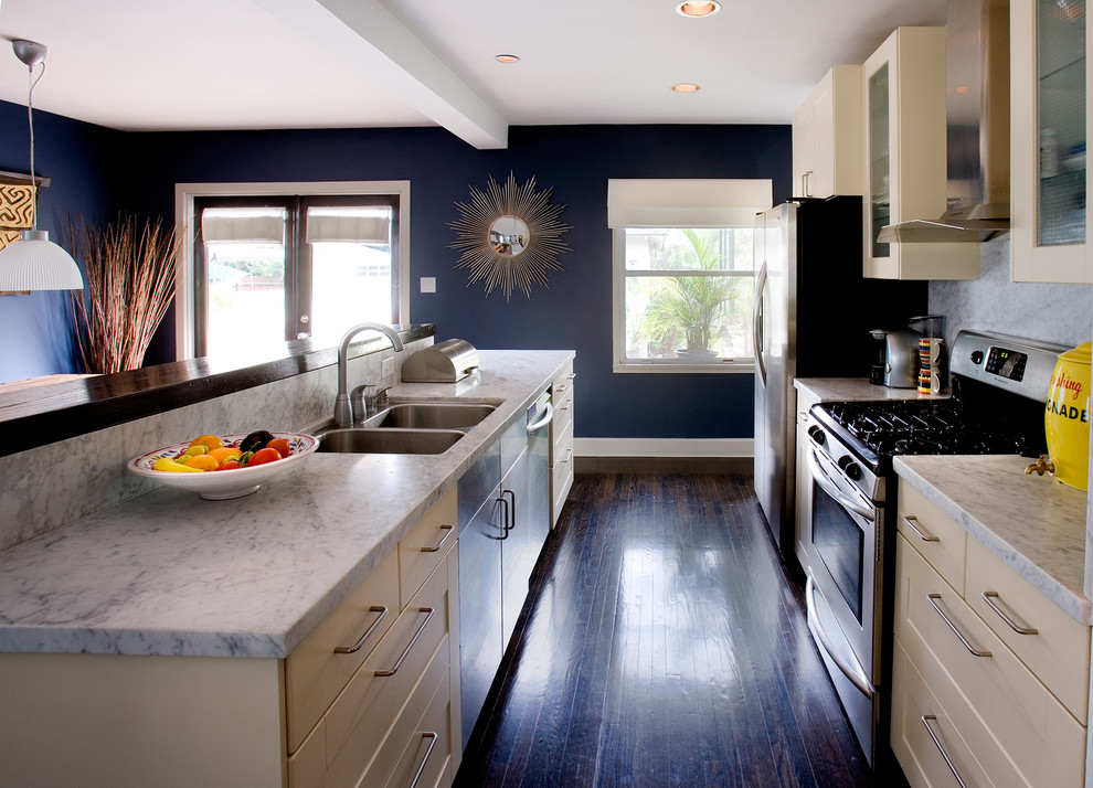 Trendy brown floor kitchen photo in Los Angeles with a double-bowl sink and marble backsplash