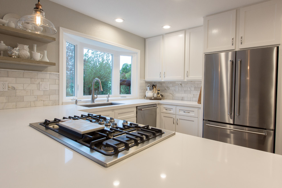 Moderne Wohnküche in L-Form mit Unterbauwaschbecken, weißen Schränken, Quarzwerkstein-Arbeitsplatte, Küchenrückwand in Weiß, Rückwand aus Metrofliesen und Küchengeräten aus Edelstahl in Sacramento