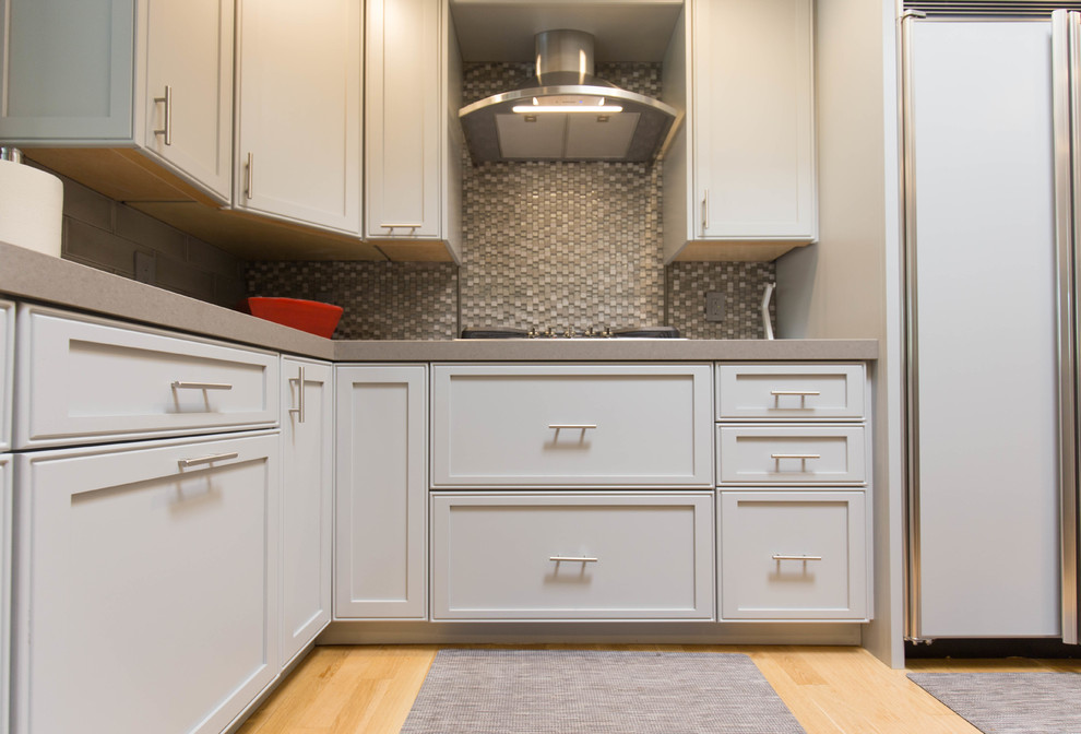 Foto på ett funkis kök, med en undermonterad diskho, grå skåp, bänkskiva i kvarts, grått stänkskydd och en köksö