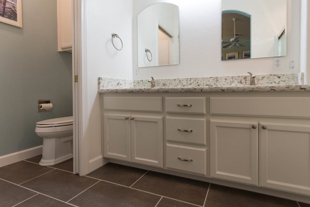 Minimalist kitchen photo in Sacramento with an undermount sink, white cabinets, quartz countertops, beige backsplash, travertine backsplash, stainless steel appliances and an island