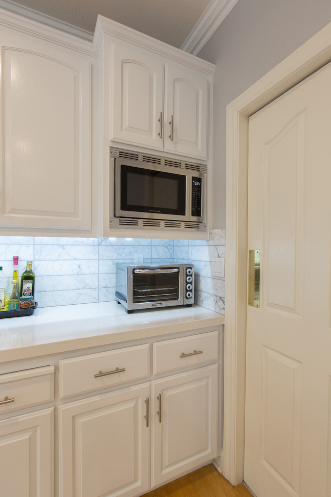 Moderne Küche in U-Form mit Unterbauwaschbecken, weißen Schränken, Quarzwerkstein-Arbeitsplatte, Küchenrückwand in Weiß, Rückwand aus Keramikfliesen und Halbinsel in Sacramento
