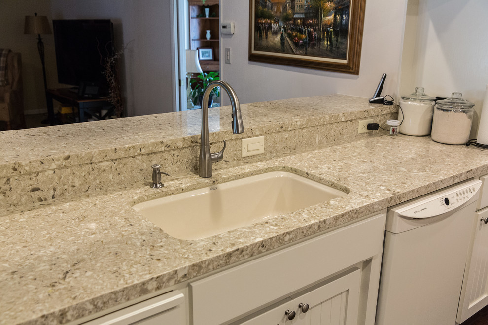 Photo of a traditional kitchen in Sacramento with a submerged sink, shaker cabinets, white cabinets, engineered stone countertops, beige splashback, glass tiled splashback and white appliances.