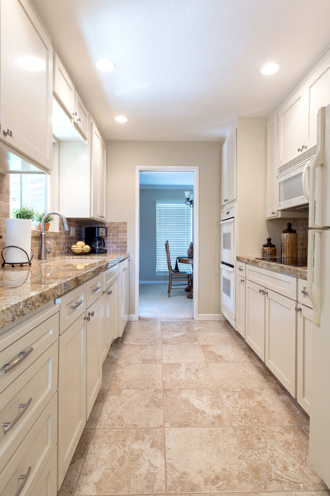 Modern galley kitchen in Sacramento with a submerged sink, white cabinets, beige splashback and white appliances.
