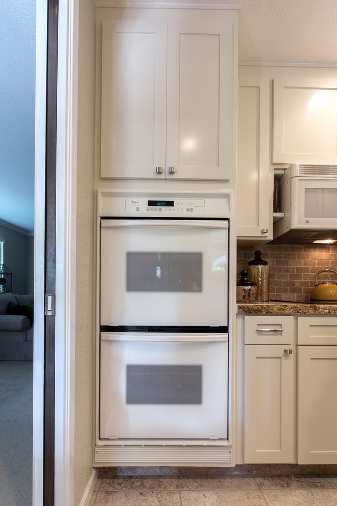 Ejemplo de cocina moderna con fregadero bajoencimera, puertas de armario blancas, salpicadero beige y electrodomésticos blancos