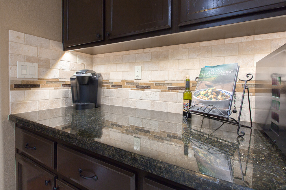 Cette photo montre une cuisine avec un évier 1 bac, des portes de placard marrons, un plan de travail en granite, une crédence beige, un électroménager en acier inoxydable et îlot.