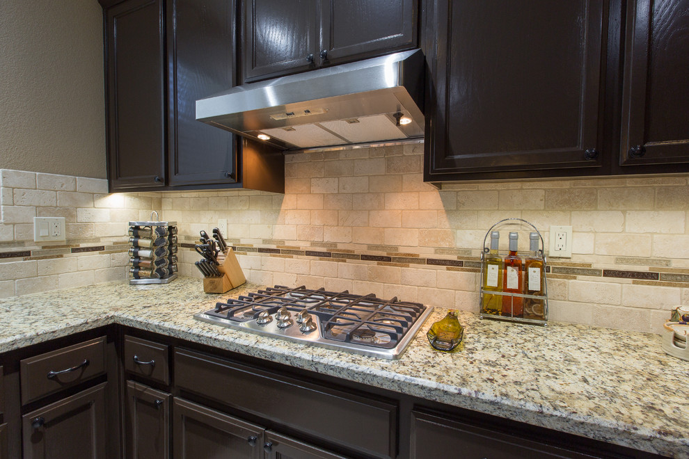 Exempel på ett kök, med en enkel diskho, bruna skåp, granitbänkskiva, beige stänkskydd, rostfria vitvaror och en köksö