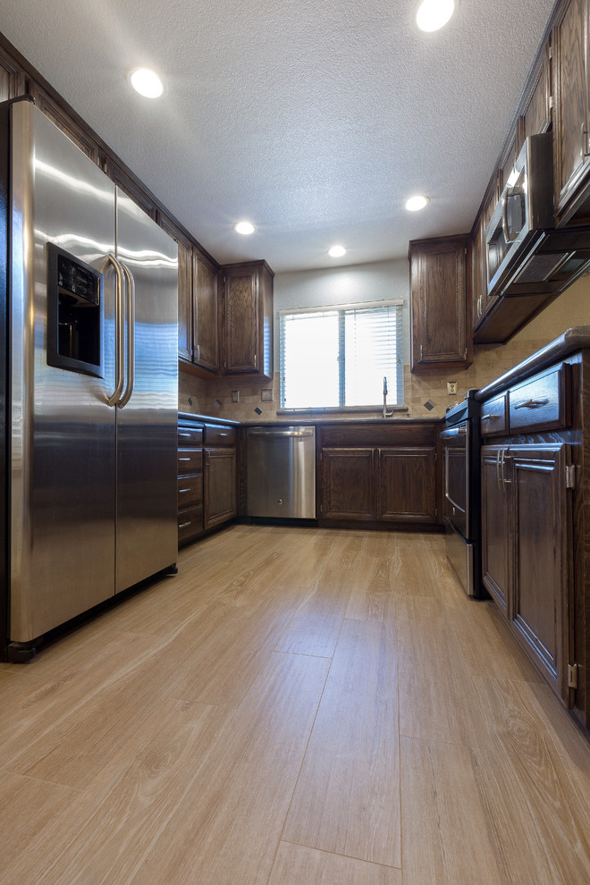 Example of a classic u-shaped porcelain tile kitchen design in Sacramento with quartz countertops, beige backsplash, stainless steel appliances and a peninsula