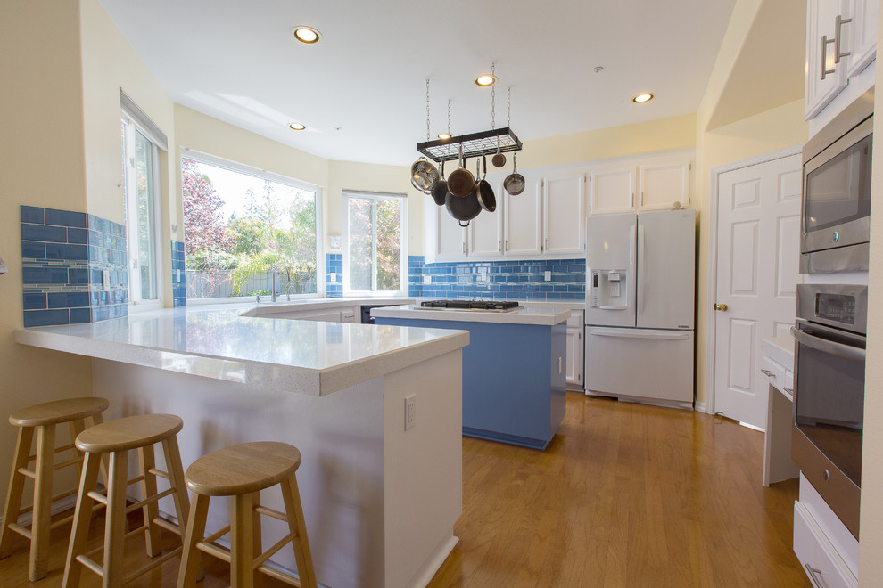 Ejemplo de cocinas en U minimalista con fregadero bajoencimera, puertas de armario blancas, encimera de cuarzo compacto y salpicadero azul