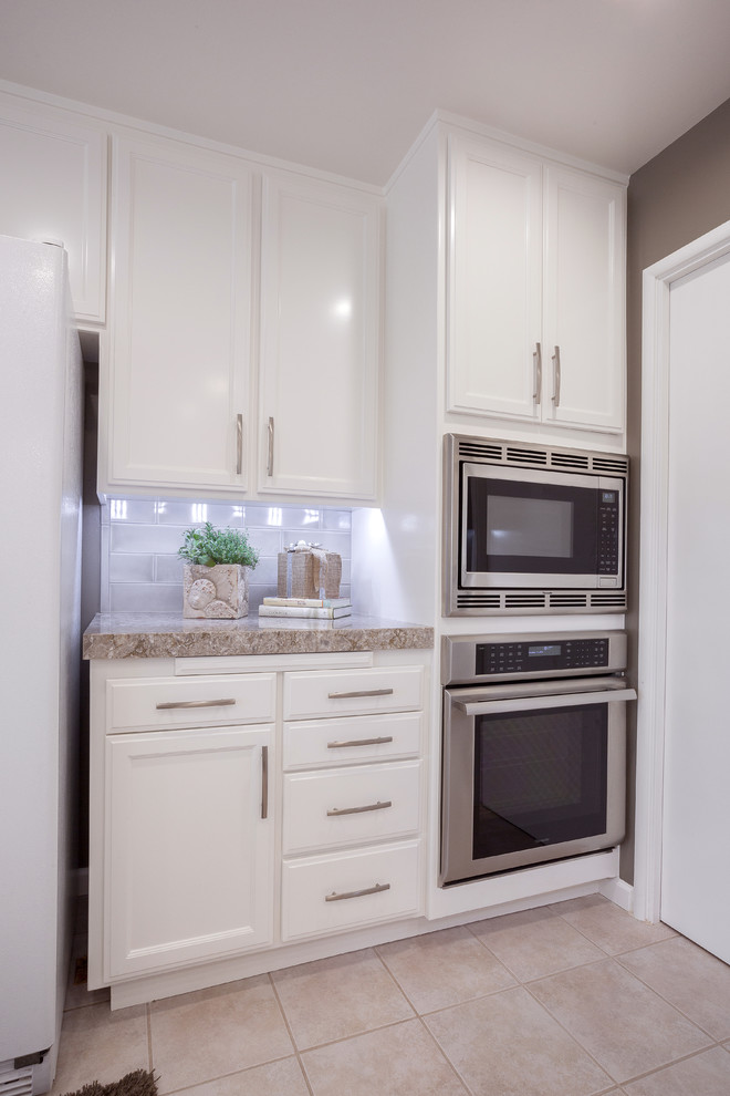 This is an example of a modern u-shaped kitchen in Sacramento with a submerged sink, white cabinets, engineered stone countertops, grey splashback, ceramic splashback and stainless steel appliances.