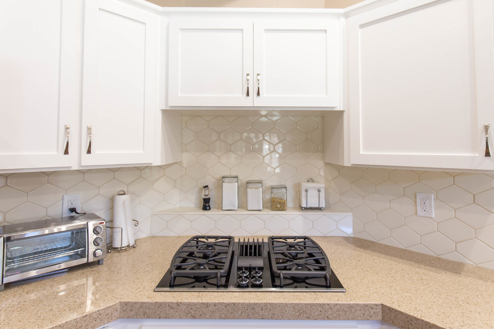 Inspiration for a modern kitchen remodel in Sacramento with an undermount sink, white cabinets, quartz countertops, mosaic tile backsplash, stainless steel appliances and an island