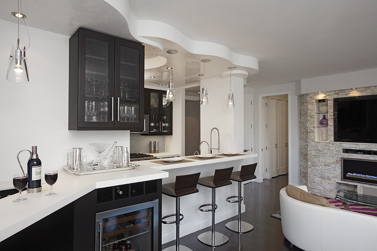 This is an example of a small contemporary single-wall open plan kitchen in New York with black cabinets, stainless steel appliances, dark hardwood flooring, no island, a submerged sink, glass-front cabinets, composite countertops, white splashback and matchstick tiled splashback.