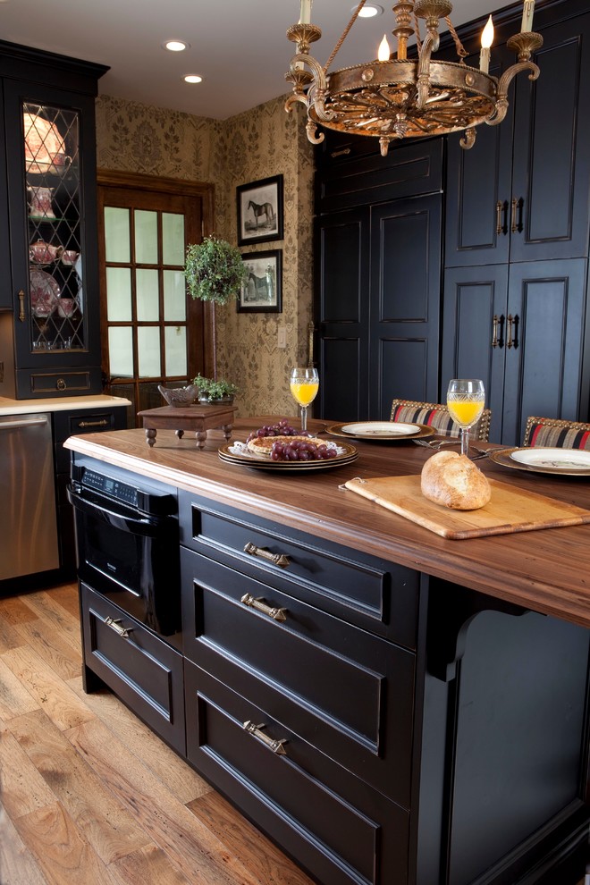 Esempio di una grande cucina chic con ante con riquadro incassato, ante nere, top in legno, elettrodomestici neri, pavimento in legno massello medio e paraspruzzi beige