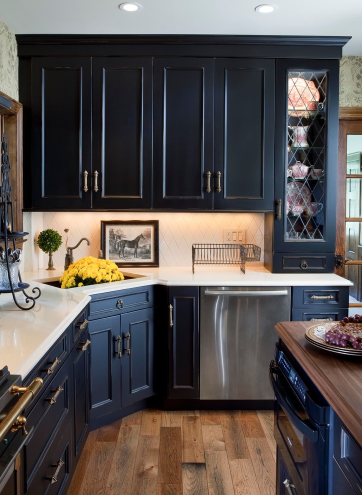 Large elegant u-shaped medium tone wood floor eat-in kitchen photo in New York with recessed-panel cabinets, black cabinets, wood countertops, black appliances, an island and beige backsplash