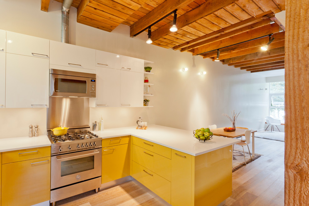 Urige Küche mit Küchengeräten aus Edelstahl, flächenbündigen Schrankfronten, gelben Schränken und Mauersteinen in Sonstige