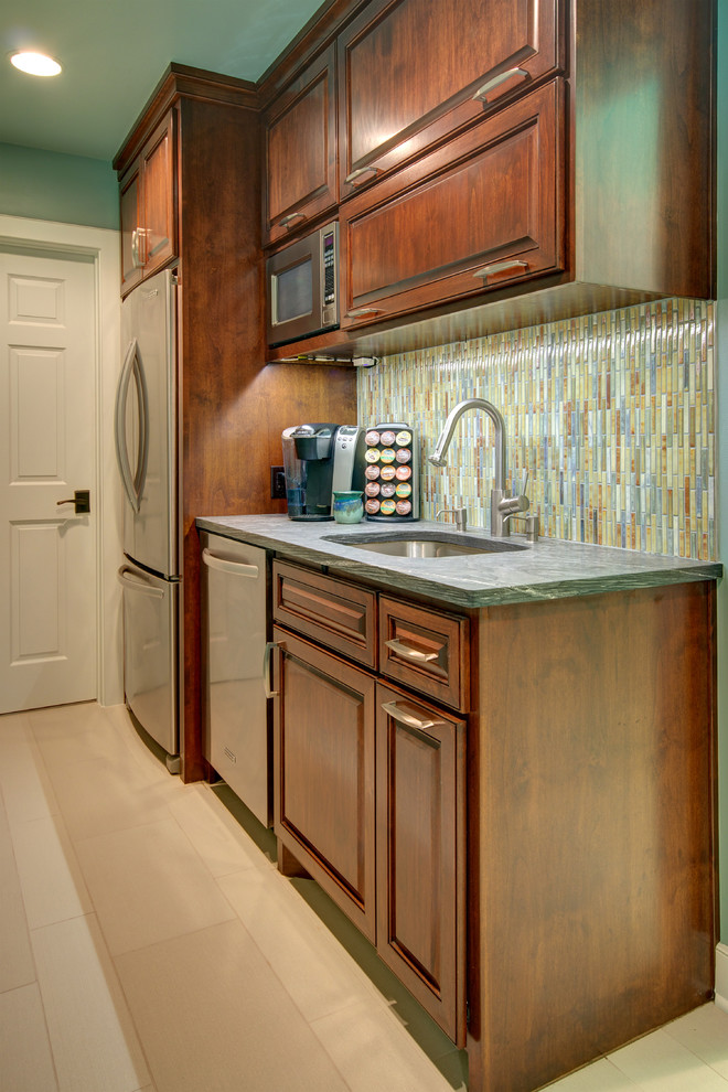 Example of a small trendy single-wall porcelain tile kitchen pantry design in Austin with an undermount sink, raised-panel cabinets, medium tone wood cabinets, soapstone countertops, multicolored backsplash, mosaic tile backsplash, stainless steel appliances and no island