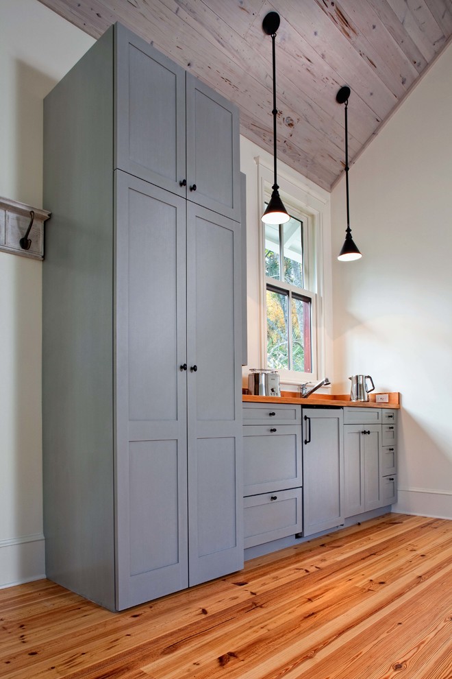 Idée de décoration pour une petite cuisine linéaire et encastrable tradition avec un placard à porte shaker, des portes de placard grises, un plan de travail en bois, un sol en bois brun et un évier encastré.