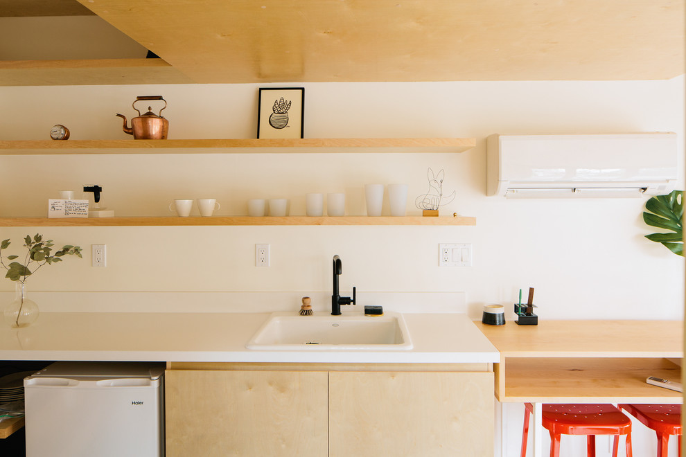 Foto på ett mellanstort funkis vit kök, med en nedsänkt diskho, släta luckor, skåp i ljust trä, bänkskiva i koppar, vita vitvaror, ljust trägolv och beiget golv