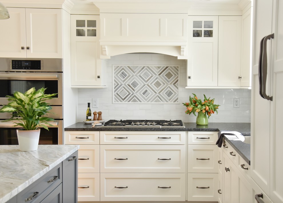 Design ideas for a classic kitchen in Boston with recessed-panel cabinets, white splashback, marble splashback, medium hardwood flooring and an island.