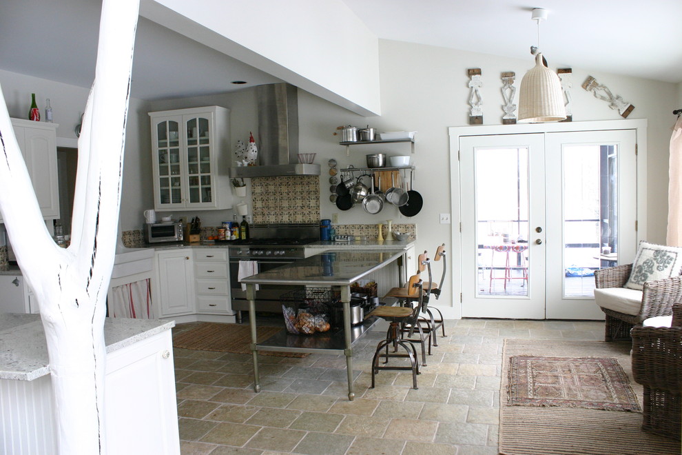 Aménagement d'une cuisine éclectique avec un évier de ferme, des portes de placard blanches et une crédence multicolore.