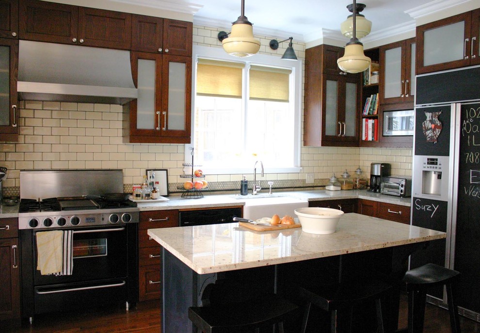 Klassische Küche in L-Form mit Landhausspüle, dunklen Holzschränken, Küchenrückwand in Beige, Rückwand aus Metrofliesen und schwarzen Elektrogeräten in Chicago