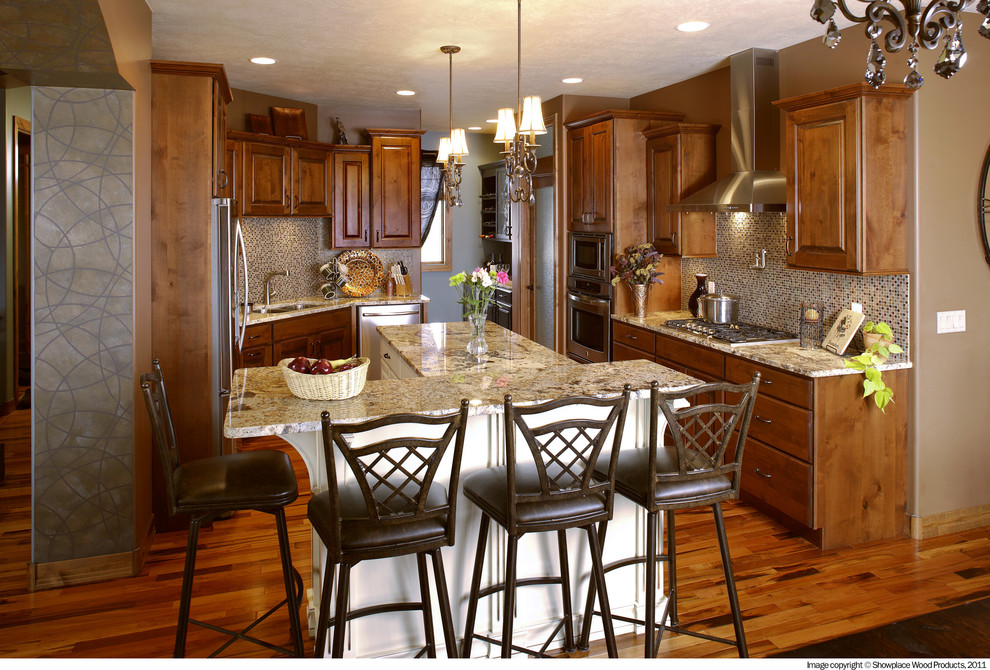 Enclosed kitchen - traditional u-shaped medium tone wood floor enclosed kitchen idea in Other with a double-bowl sink, raised-panel cabinets, medium tone wood cabinets, granite countertops, beige backsplash, mosaic tile backsplash, stainless steel appliances and an island