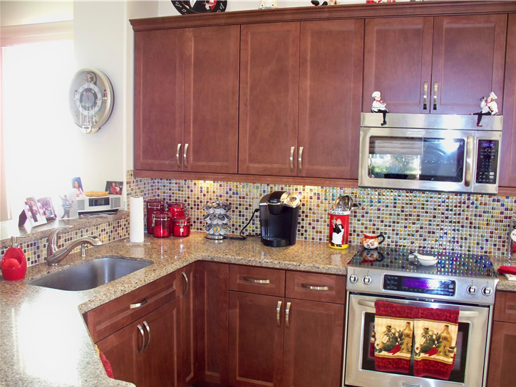 Klassisk inredning av ett mellanstort u-kök, med en nedsänkt diskho, skåp i mellenmörkt trä, beige stänkskydd, stänkskydd i keramik, rostfria vitvaror, marmorgolv och en halv köksö