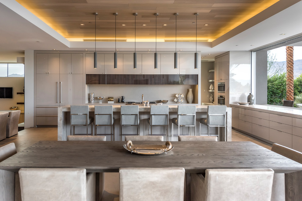 Contemporary l-shaped open plan kitchen in Other with flat-panel cabinets, grey cabinets, grey splashback, integrated appliances, concrete flooring, an island and grey floors.