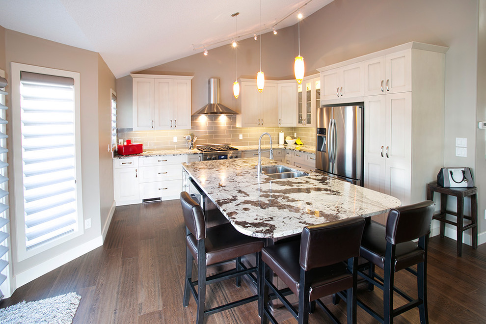 Foto di una cucina minimalista di medie dimensioni con lavello sottopiano, ante bianche, top in granito, paraspruzzi multicolore e elettrodomestici in acciaio inossidabile