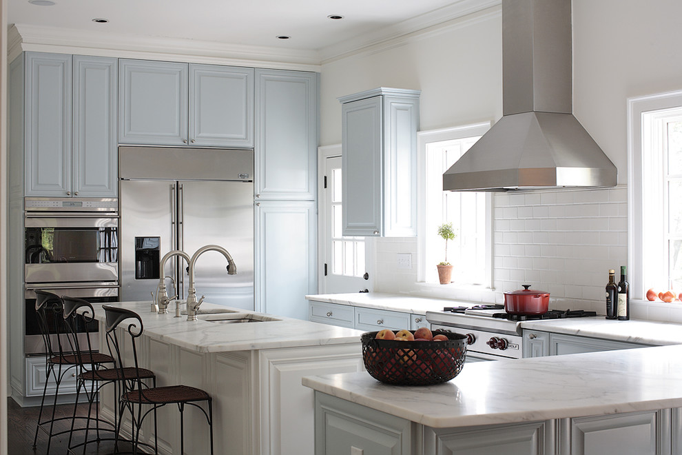 Classic kitchen in Atlanta with a submerged sink, raised-panel cabinets, blue cabinets, marble worktops, white splashback, metro tiled splashback and stainless steel appliances.