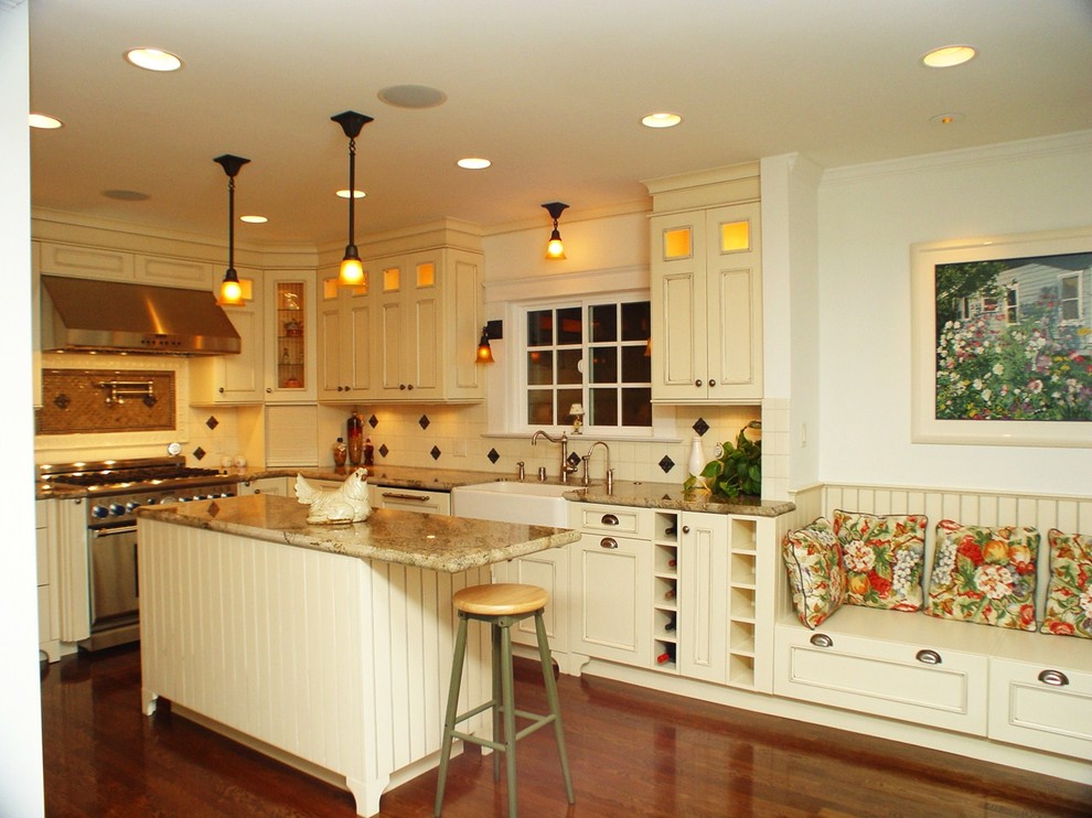 Example of a mid-sized classic l-shaped dark wood floor eat-in kitchen design in Los Angeles with a farmhouse sink, recessed-panel cabinets, white cabinets, stainless steel appliances and an island