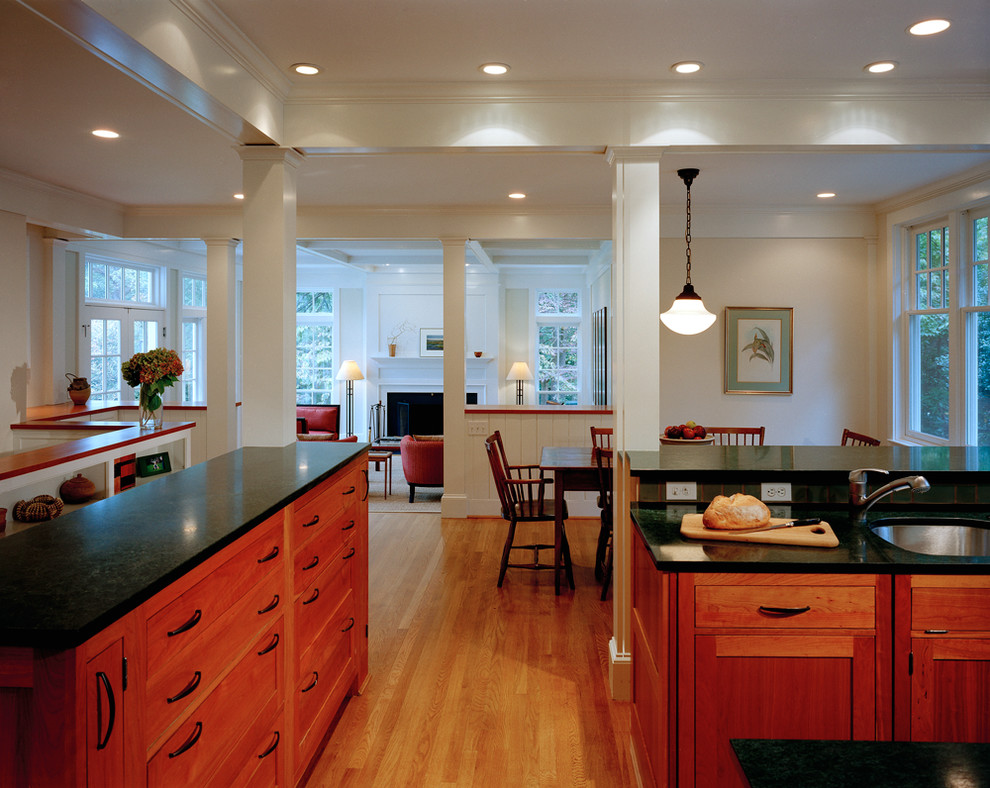 Exempel på ett mellanstort klassiskt svart svart u-kök, med en undermonterad diskho, luckor med profilerade fronter, skåp i mellenmörkt trä, blått stänkskydd, stänkskydd i keramik, rostfria vitvaror, mellanmörkt trägolv, en köksö och brunt golv