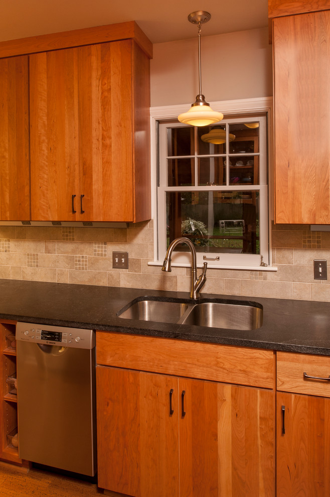 Bild på ett funkis kök, med en dubbel diskho, släta luckor, skåp i mellenmörkt trä, granitbänkskiva, grått stänkskydd, rostfria vitvaror, stänkskydd i stenkakel och mellanmörkt trägolv