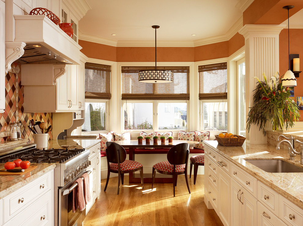 Idées déco pour une cuisine ouverte linéaire classique de taille moyenne avec un placard à porte shaker, des portes de placard blanches, une crédence beige, une crédence en feuille de verre, parquet clair et îlot.