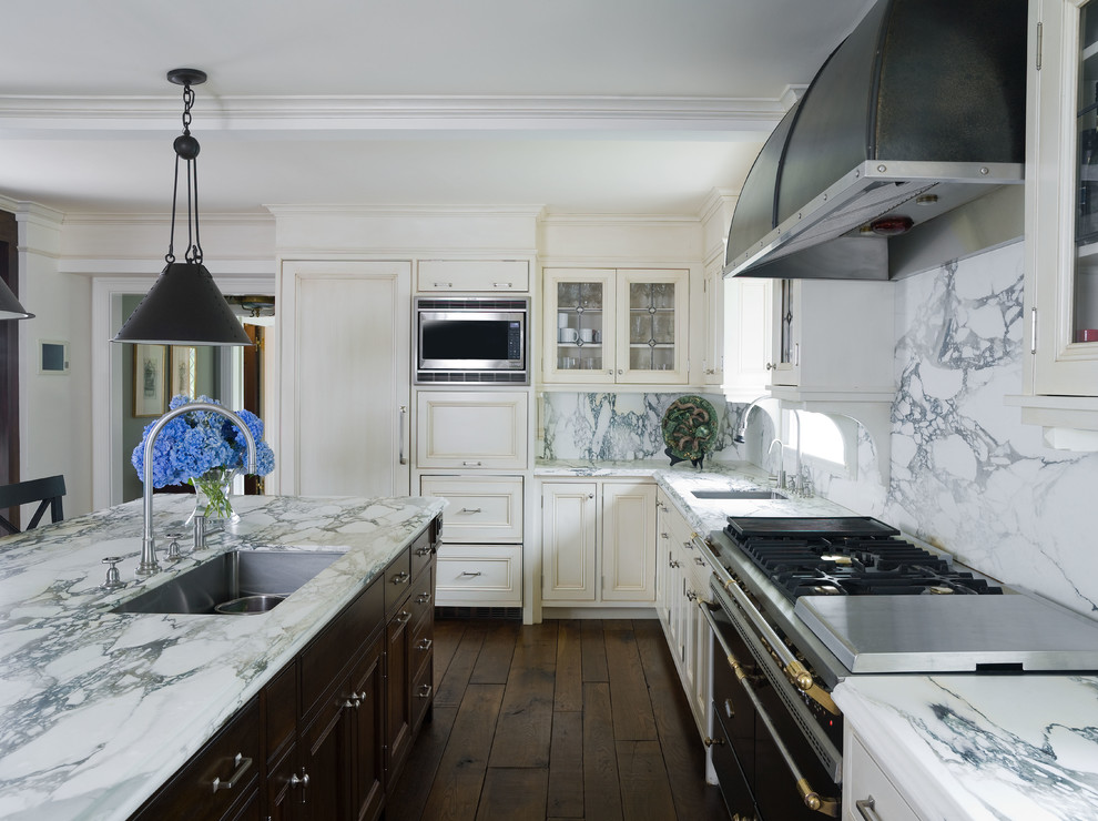 Inspiration for a classic l-shaped kitchen in New York with a submerged sink, recessed-panel cabinets, white cabinets, white splashback and integrated appliances.