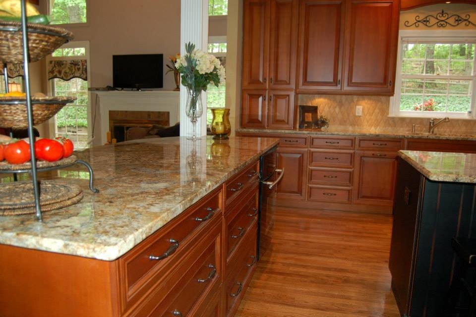 Bild på ett mellanstort vintage kök, med luckor med upphöjd panel, skåp i mellenmörkt trä, granitbänkskiva, beige stänkskydd, stänkskydd i stenkakel, mellanmörkt trägolv och en köksö