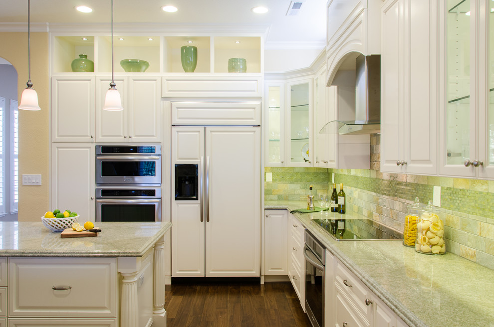 Foto på ett vintage kök, med en undermonterad diskho, luckor med upphöjd panel, vita skåp, granitbänkskiva, rostfria vitvaror, flerfärgad stänkskydd, stänkskydd i stenkakel och mellanmörkt trägolv